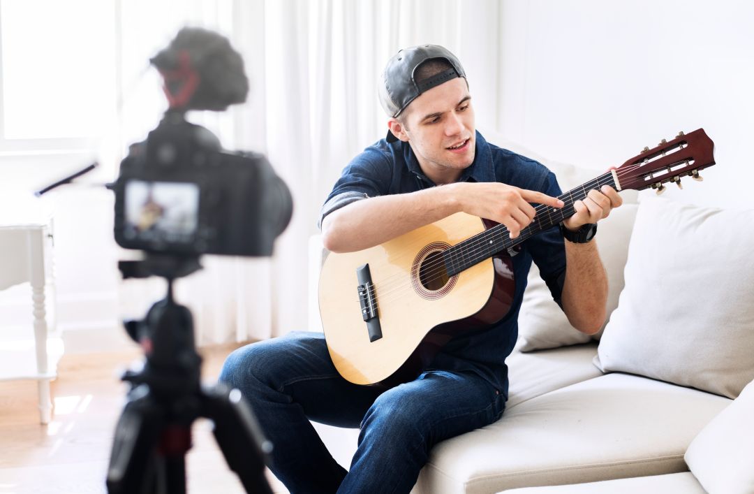 اینفلوئنسر جوان در حال آموزش گیتار به طرفداران خود 