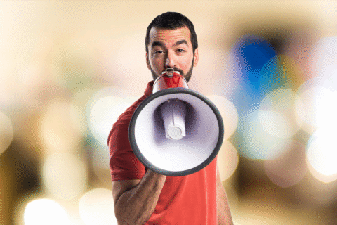 مردی بلند گو به دست در حال تبلیغات